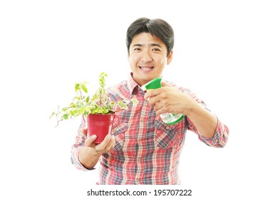 Asian Man Holding A Plant In His Hand