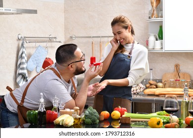 Asian Man Holding Red Box With Ring Making Propose To His Girlfriend In The Kitchen