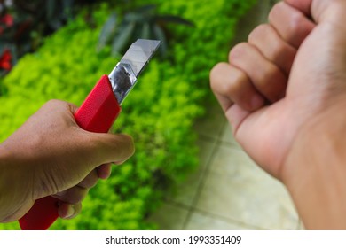 An Asian Man Holding Red Cutter Knife Tries To Harm Himself. Suicide Illustration Stock Images.