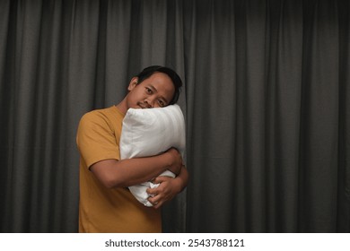 Asian man hugging soft and comfortable white pillow with delightful smile, sleeping like baby. - Powered by Shutterstock