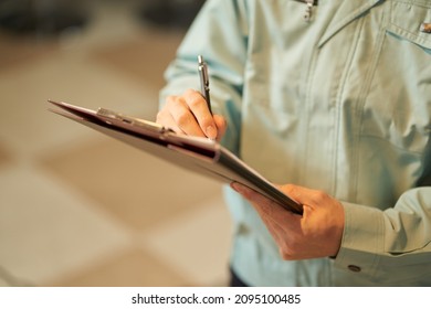 Asian Man Inspecting Restaurant Equipment