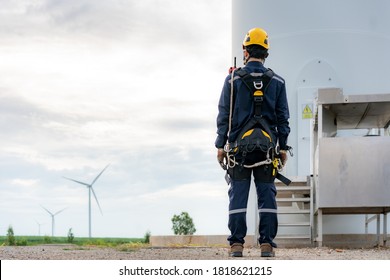 Asian man Inspection engineer preparing and progress check of a wind turbine with safety in wind farm in Thailand.