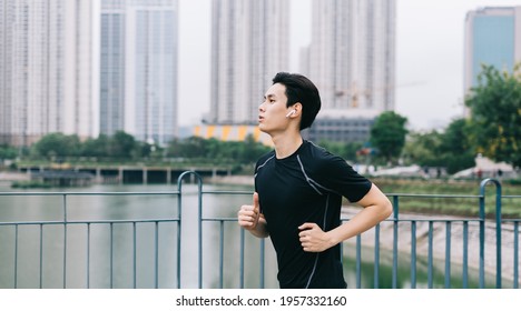 Asian Man Is Jogging In The Park
