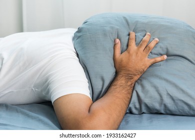 Asian Man Lie Face Down And Put A Pillow Over His Head Because The Side Of The House Makes A Loud Noise, Disturbing His Sleep. He Can't Sleep Until Morning.