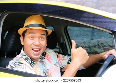 Asian Man Looking At Camera And Give Thumb Up From Inside His Car