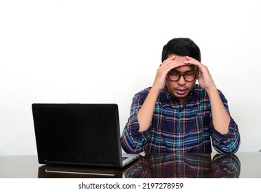 Asian Man Looking Down Languidly When Sitting Beside His Laptop