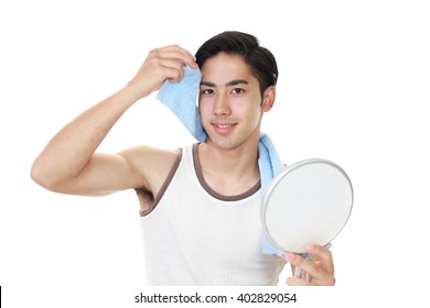 Asian Man Looking At His Face In Mirror