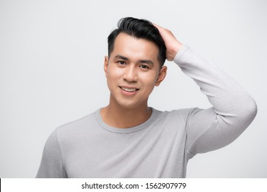 Asian Man Looking At His Hair In Mirror