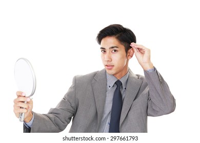 Asian Man Looking At His Hair In Mirror