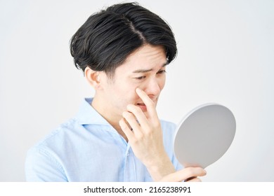 Asian Man Looking In The Mirror In White Background