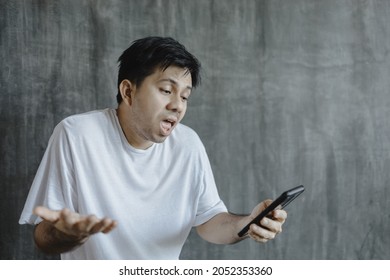 Asian Man Looking At Smartphone In A Bad Mood Technological Intelligence Internet Outage