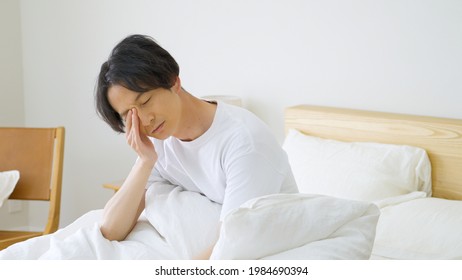Asian man lying in bed