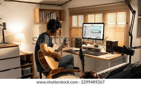 Asian man making music at home studio