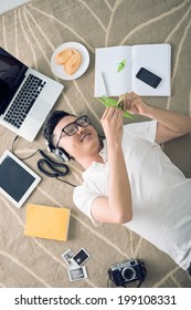 Asian Man Making Origami Cranes While Listening To The Music, View From The Top