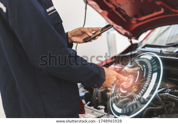 Asian Man mechanic inspection Shine a torch car engine\
checking bug in engine from application smartphone.Red car for\
service maintenance insurance with car engine.for transport\
automobile automotive 