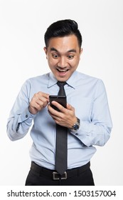 Asian man in office wear looking at his handphone with being success expression