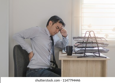 Asian Man Officer Have Back Pain While Sitting On A Chair At His Desk
