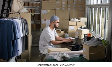 Asian Man Online Seller Confirming Orders From Customer On Laptop. E-commerce Male Business Owner Working On Laptop Computer In Store Warehouse.