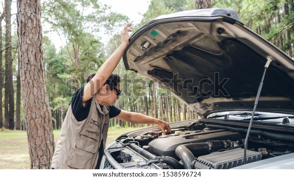Asian man Opening the bonnet of his pickup truck\
to check the condition of the engine failure, to be ready for\
travel, to transportation\
concept.