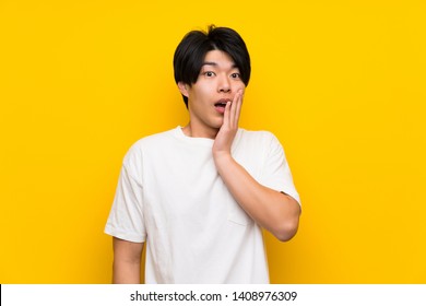 Asian man over isolated yellow wall with surprise and shocked facial expression - Shutterstock ID 1408976309