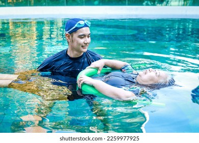 Asian man or physiotherapist helping elderly female patient with hydrotherapy It is a rehabilitation and exercise in the water. physical therapy center - Powered by Shutterstock