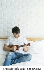 Asian Man Play Guitar At Home, Feel Relaxing 