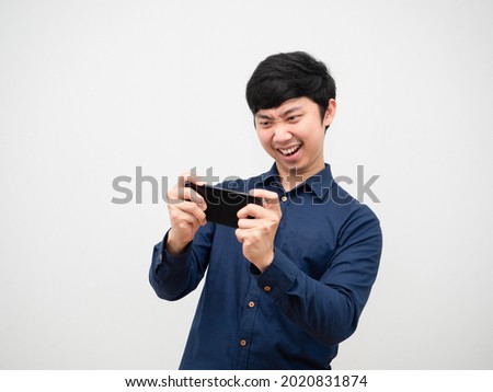 Asian man playing game on mobilephone feeling fun on white background