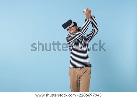 asian man playing a game in virtual reality. Active young man play golf while wearing virtual reality goggles. Sporty young man exploring immersive virtual reality games.