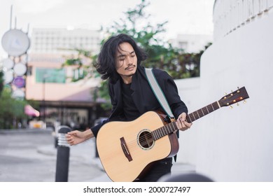 Asian Man Playing Guitar Music Festival On Street 