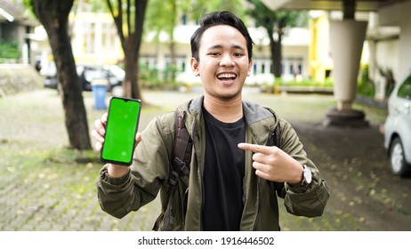 Asian Man Pointed At The Green Screen Cell Phone With A Smile