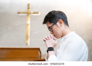 Asian Man Praying In A Worship Room In A Christian Church.