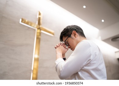 Asian Man Praying In A Worship Room In A Christian Church.