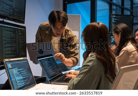 Asian man presents code using a projector during a software development meeting or coding workshop, guiding attendees through problem-solving and programming concepts in an educational setting.