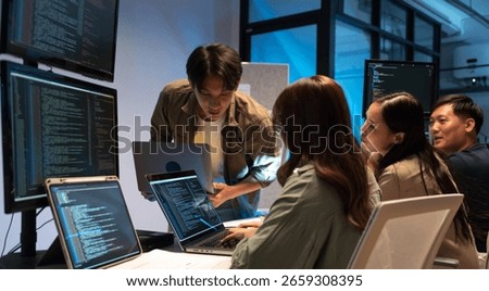 Asian man presents code using a projector during a software development meeting or coding workshop, guiding attendees through problem-solving and programming concepts in an educational setting.