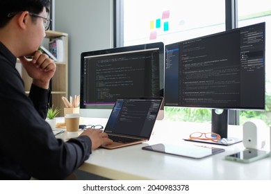Asian man programmer working at at modern office. Developing programming.	