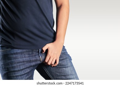 Asian man in reaction of scratching crotch on white background, closeup. Annoying itch or Tinea Cruris. Human body problem or healthcare and medicine concept.
					