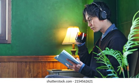 Asian man reading a book in luxury room.