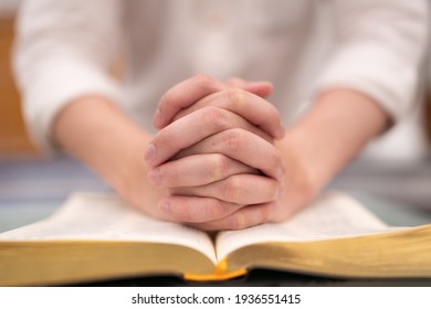 Der asiatische Mann liest die Heilige Bibel und betet in einem Gotteszimmer in einer christlichen Kirche.