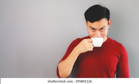 Asian Man In Red T-shirt Is Drinking A Cup Of Coffee, Tea.