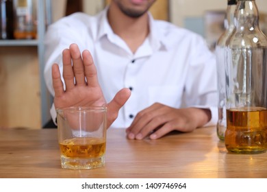 Asian Man Refuses To Drink A Alcohol By Stopping Hand Sign. Male Alcoholism Concept. Treatment Of Alcohol Addiction. Quit Booze And Alcoholism