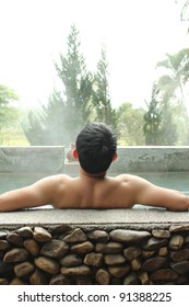 Asian Man Relaxing In Outdoor Japanese Hot Bath.