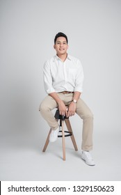 Asian Man Relaxing While Sitting On The Chair On White Background