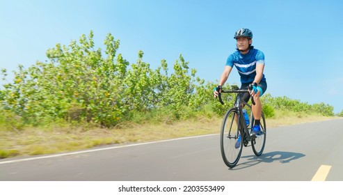 Asian Man Ride A Bicycle On Countryside Happily