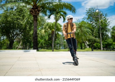 An Asian Man Rides An Electric Scooter To Work.