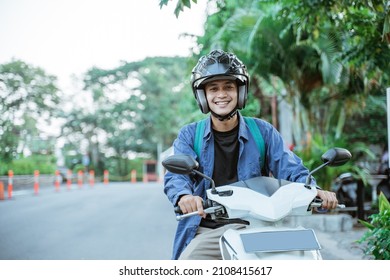Asian man riding a motorcycle on the street - Shutterstock ID 2108415617