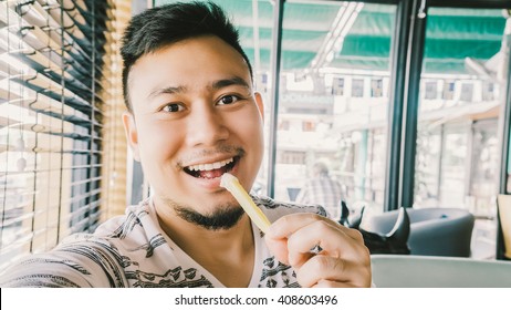 Asian Man Selfie And Eating French Fries.