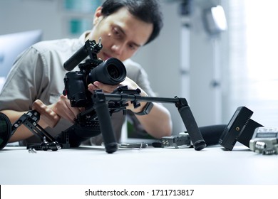 An Asian Man Is Setting Up A Camera Rig 