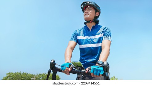 Asian Man Setting The Phone Going To Ride A Bicycle On Countryside Happily