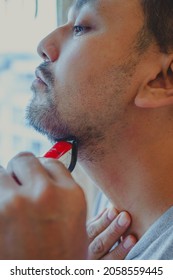 Asian Man Shaving Beard With Electric Razor Machine.