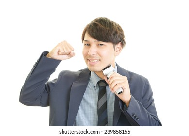 Asian Man Shaving With Electric Razor